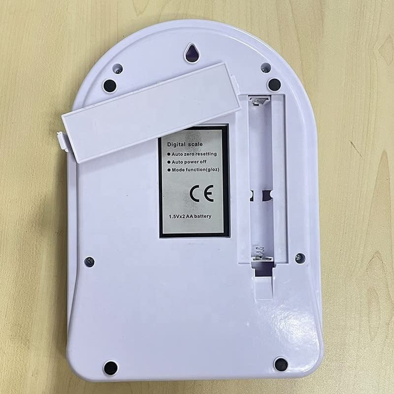 White electronic device with battery compartment on a wooden surface