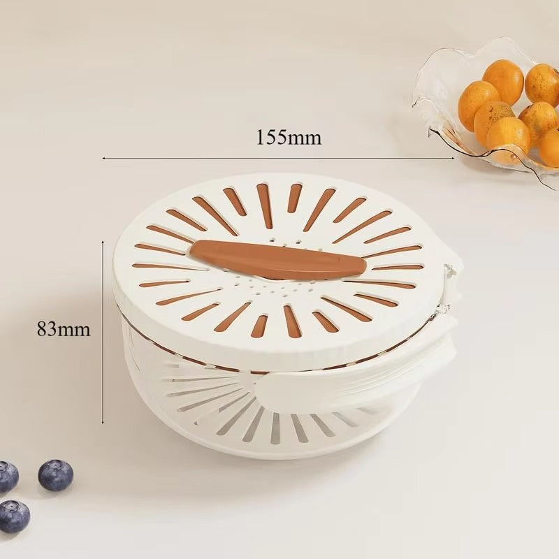 White kitchen tool with brown accents on a light background, showing measurements and a small bowl of oranges.