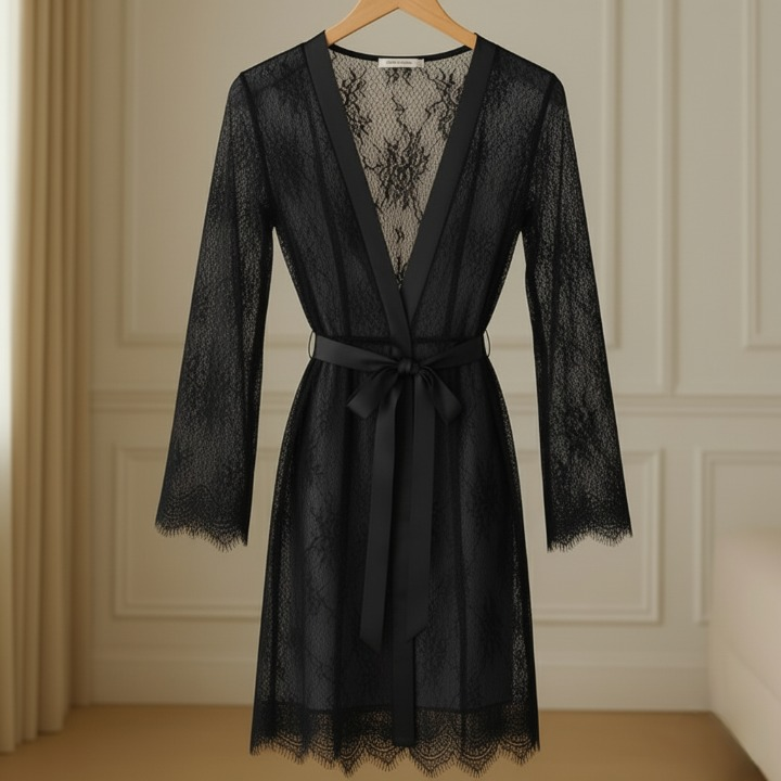 Black lace robe on a hanger against a neutral wall.