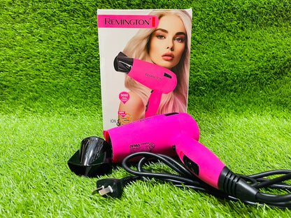 Pink hair dryer with black attachments on grass, accompanied by a Remington packaging featuring a model with styled hair.