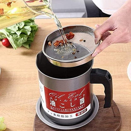 Person pouring oil into a kitchen tool on a wooden surface with vegetables in the background
