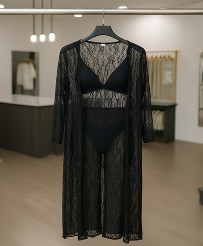 Black lace lingerie set with matching robe on a hanger in a store setting.