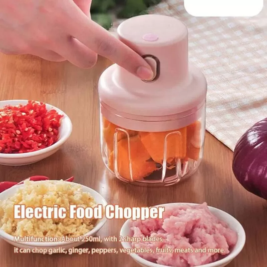 Electric food chopper with chopped ingredients on a wooden table