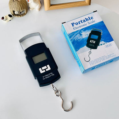Portable electronic scale with its packaging on a white surface