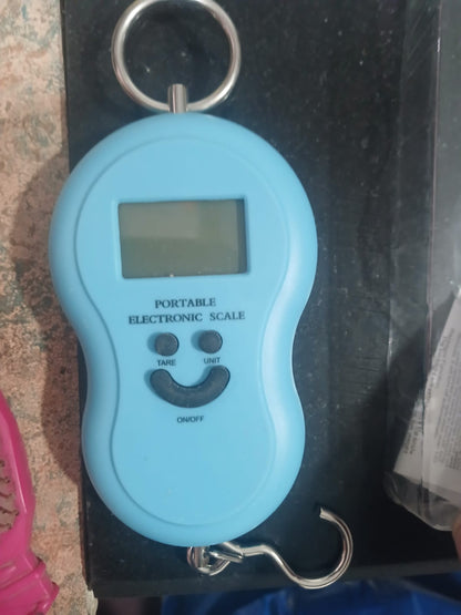 Blue portable electronic scale with a digital display on a dark surface.