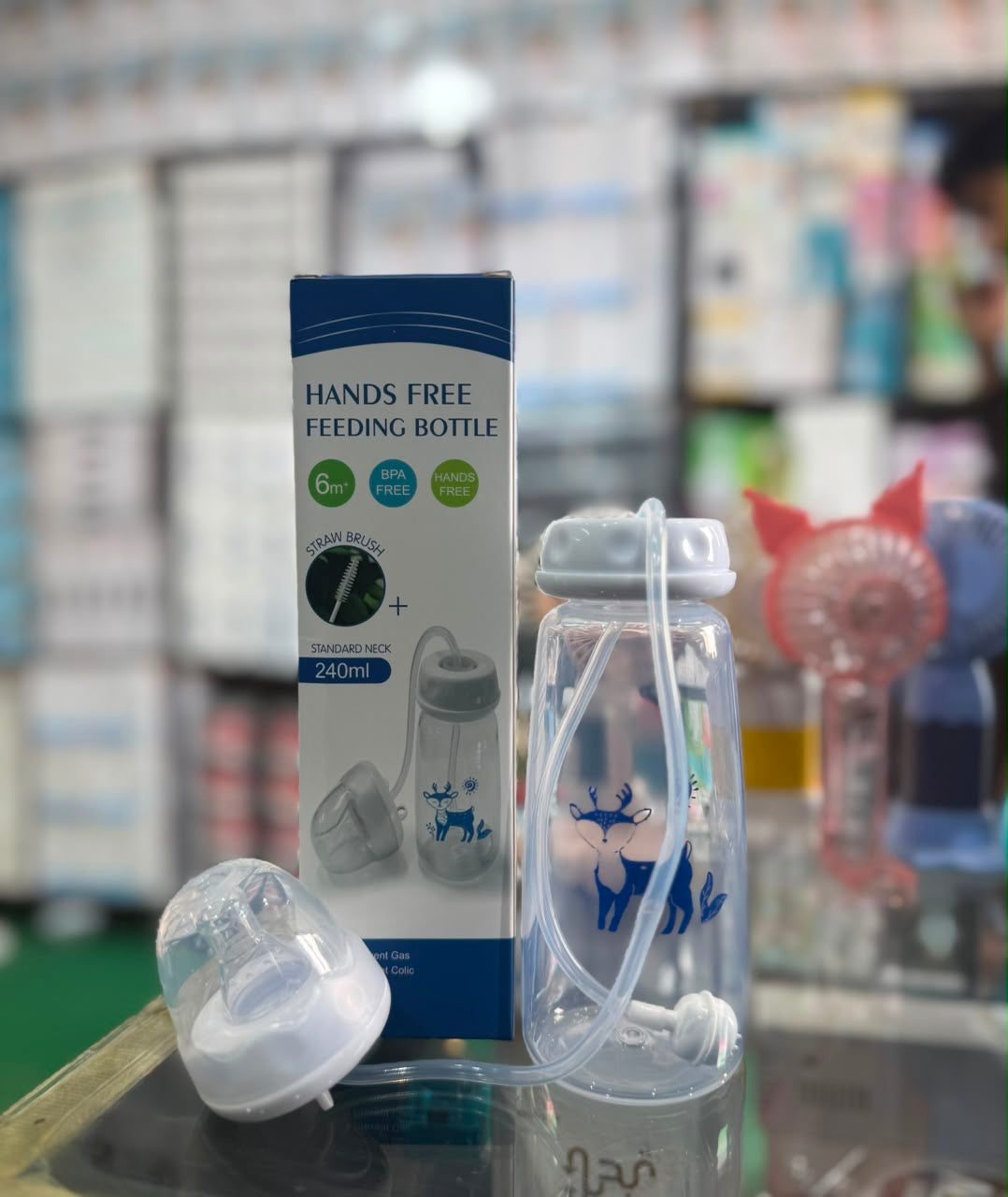 Hands-free feeding bottle with packaging on a store shelf