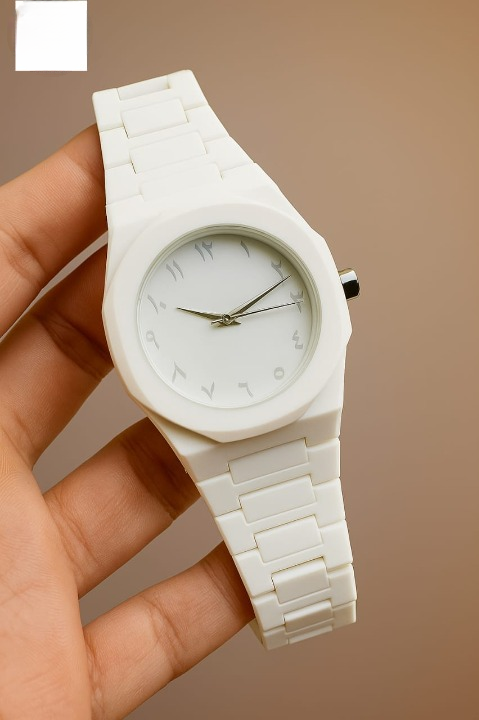 White watch held in a hand against a brown background