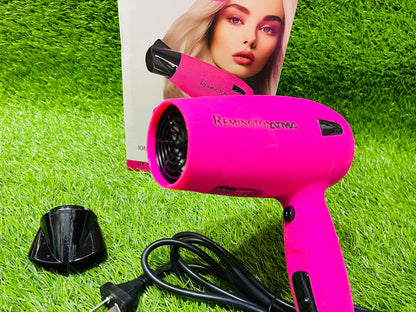 Pink Remington hair dryer on grass with a product packaging featuring a model.