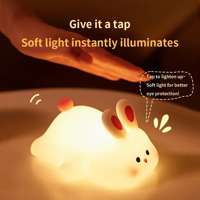 Cute rabbit-shaped night light with a hand tapping it, illuminating text on a dark background.