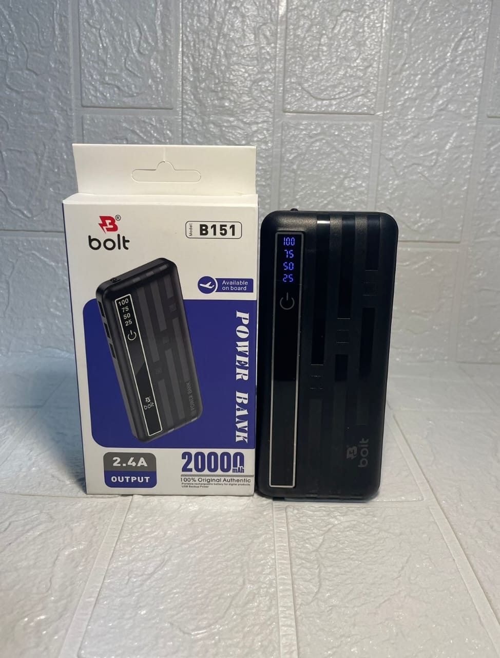 A black Bolt B151 portable power bank standing next to its white and blue retail box on a light textured surface.