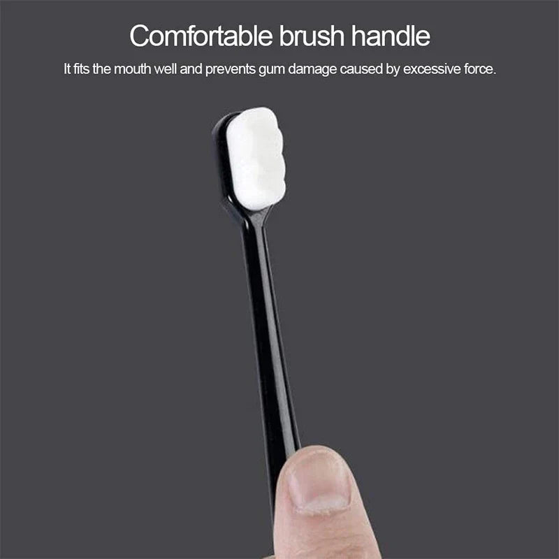 Black toothbrush handle with a white bristle head held by a hand against a dark background