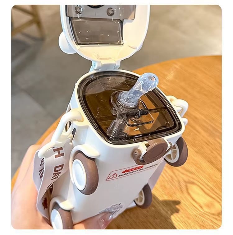 Close-up of a white robot-like device with a transparent component on a wooden surface.