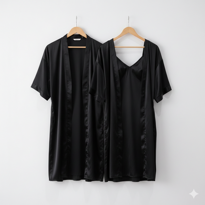Two black satin garments on hangers against a white background