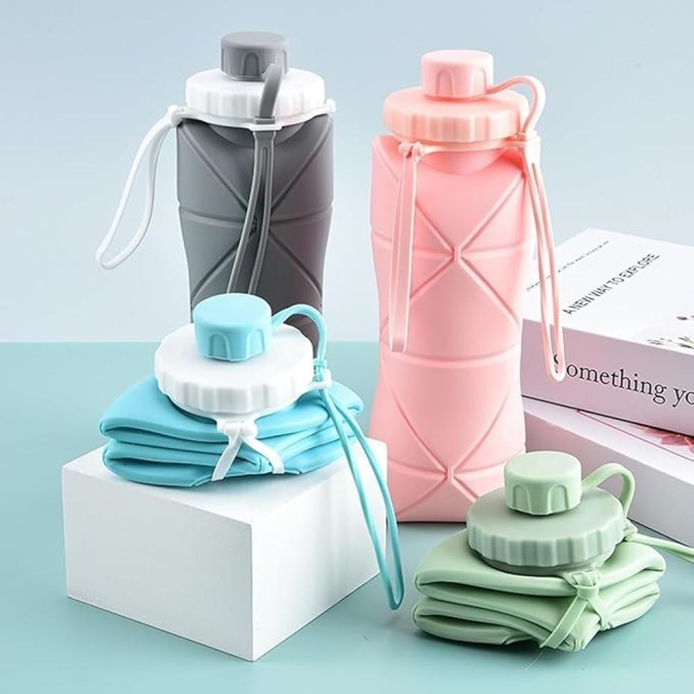 Set of three collapsible water bottles in gray, pink, and green on a light blue background.