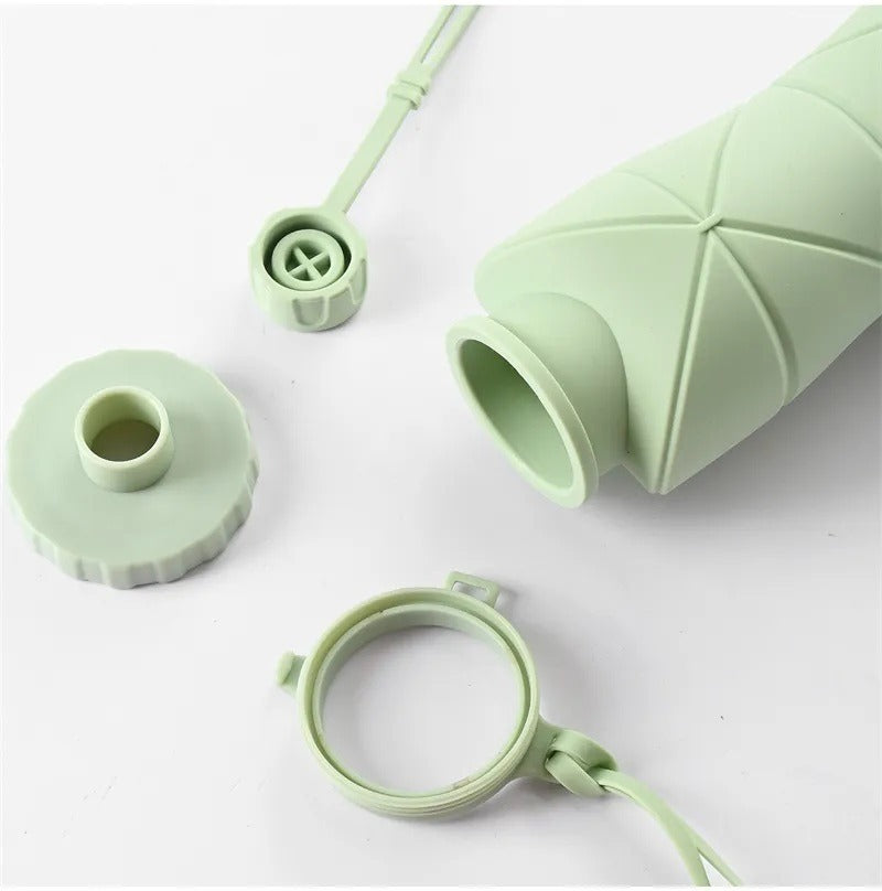 Green silicone bottle components on a white background