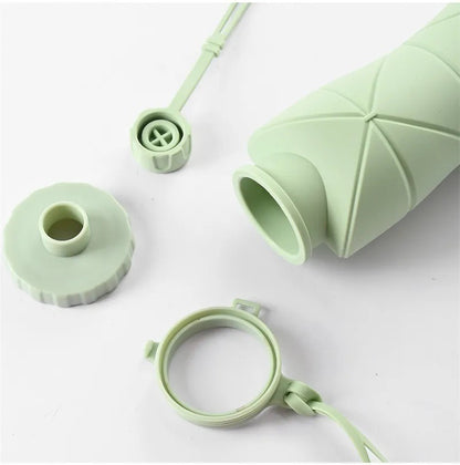 Green silicone bottle components on a white background